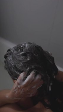 Bir insanı duşta saçlarını yıkarken yakalamak, özbakımı ve rahatlığı somutlaştırmak..