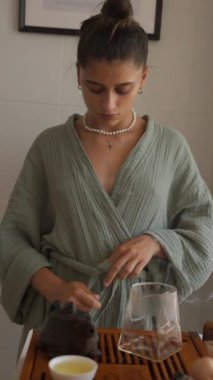 Huzurlu ve sakin bir sabah sahnesi, çay ayininden hoşlanan genç bir kadını gözler önüne seriyor.