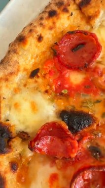 Çekici bir yakın çekim, taze pişmiş pepperonili pizza, erimiş peynir ve mükemmel derecede çıtır çıtır.