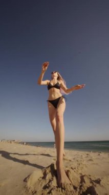 Sahilde gençliğin ve neşenin özünü yansıtan canlı bir sahne, güneşin altında canlı ve neşeli bir enerji sergiliyor.