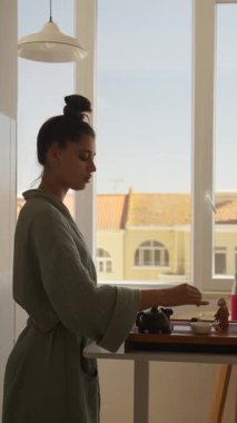 Huzurlu ve güzel bir sabah sahnesinde bir kadın parlak bir güneş ışığı penceresiyle satranç oynamaya derinden odaklanır.