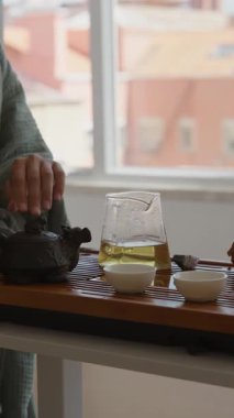 Doğal elementlerle birlikte geleneksel yöntemleri güzel bir şekilde sergileyen sakin ve sakin bir çay demleme oturumu