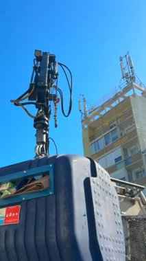 Bir Cuttingedge otomatikleştirilmiş atık toplama sistemi kalabalık bir şehir ortamında etkili bir şekilde bir çöp konteynırını kaldırıyor