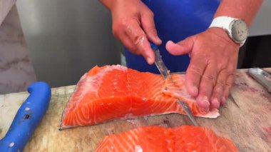 Taze somon filetosu için uzman teknikleri göstermek, profesyonel mutfak becerileri ve sanatsal becerileri vurgulamak