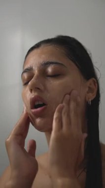 Bir kadın, duşta besleyici bir temizlik rutiniyle cildini canlandırır. Etkili cilt bakımı yapar.