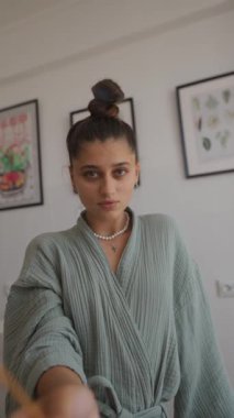 Rahat bir bornoz giyen modaya uygun bir manken büyüleyici sanatsal yeteneği ve zarafetiyle etrafındaki herkesi kendine çekiyor.