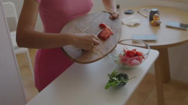 Bir birey, parlak bir mutfak ortamında çeşitli taze, renkli meyve ve sebzeler hazırlar.