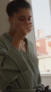 Huzurlu bir an, rahatlatıcı bir fincan çay, huzur dolu, aydınlık bir odada rahatlama ve bencilliği yansıtıyor.