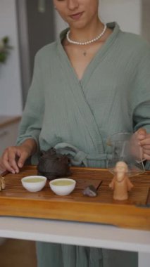 Huzurlu bir çay seremonisine katılan bir kadın çay hazırlama sanatını ve sükuneti sergiliyor.