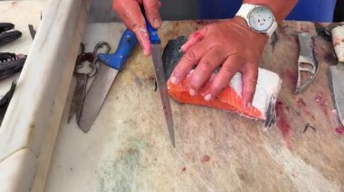 Bu sunumda taze somon balıklarının ustalıkla doğranması için son derece yetenekli teknikler yer alıyor.