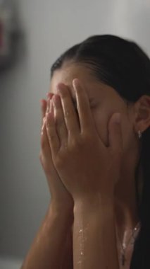 Duştayken karmaşık cilt bakımını yapan ve eğlenen bir kadının büyüleyici yakın çekimleri.