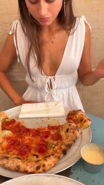 Moda bir lokantada, şık bir insan nefis bir pepperonili pizzadan zevk alırken telefonuyla o anı yakalıyor.