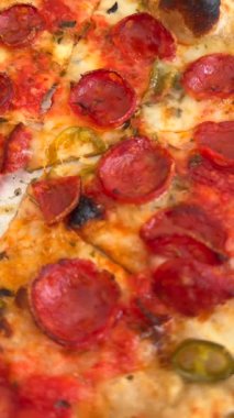 Lezzetli bir biberli pizzanın yakın plan çekimi. Canlı malzemeler ve çıtır çıtır, altın sarısı kabuklu.