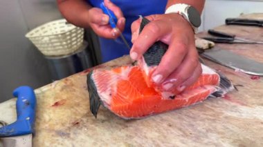 Becerikli bir balıkçı filetosu pazarda taze somon balığı, fevkalade bir aşçılık ve sanatsal uzmanlık sergiliyor.