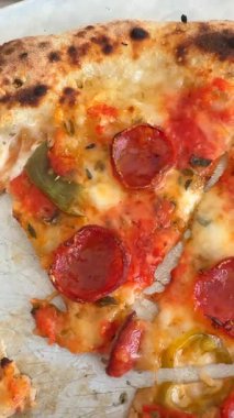 Lezzetli bir biberli pizzanın yakın plan fotoğrafı. Pizzacılar için taze sebzelerle süslenmiş.