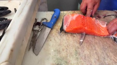 Yetenekli ve deneyimli eller, enfes mutfaklar yaratmak için taze somonları ustalıkla kesiyorlar.