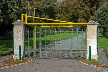 İngiltere 'nin Weston-super-Mare kentindeki Ashcombe Park' a giren araçların yüksekliğini değiştirmek için kurulan yeni bir bariyer mevcut park kapılarıyla çarpıcı bir tezat oluşturuyor. 