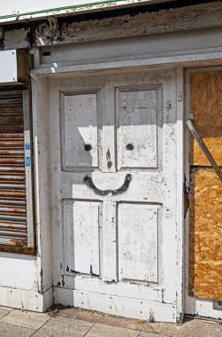 Weston-super-Mare, İngiltere 'de kullanılmayan bir mağazanın kapısında kabaca boyanmış bir yüz.