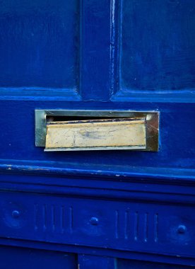 A broken letterbox in a blue door clipart