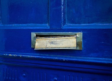 Kırık bir posta kutusu mavi bir kapıda