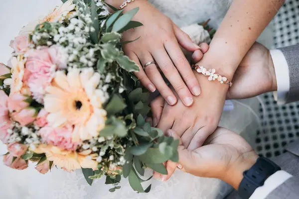 Gelin ve damat, ellerini pastel renkte bir buketin üzerine koyarken çok güzel bir an yakaladılar.. 