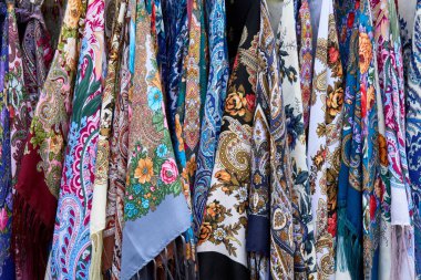 Canlı çiçekli ve desenli renkli geleneksel eşarplar, zengin tekstil tasarımları ve kültürel sanatlar sergiliyor.