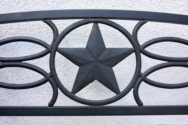 Beyaz desenli arka planda siyah dövmeli demir yıldız süslemesi. Güç, gelenek ve vatanseverliği sembolize eden dekoratif metal işleri.