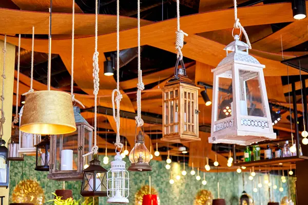 Değişik stil ve malzemelerle dekoratif fener ve lambalar asılıydı. Ahşap bir tavandan sarkıtılan iplerle sıcacık bir iç mekan.