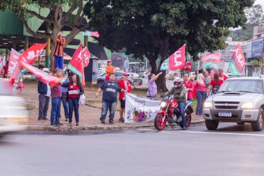 Sokakta Lula 'nın kırmızı bayraklarıyla dolaşan birkaç kişi var. Görüntü, Lula 'ya oy istemek için yapılmış..