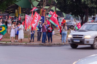 Sokakta Lula 'nın kırmızı bayraklarıyla dolaşan birkaç kişi var. Görüntü, Lula 'ya oy istemek için yapılmış..