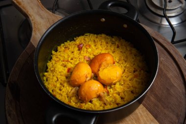 Tahtaya pequi sürülmüş siyah bir tava. Tipik bir Brezilya yemeği..