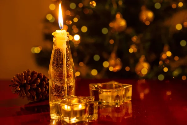 Juldekoration Ett Tänt Ljus Förgrunden Och Suddig Julgran Bakgrunden — Stockfoto
