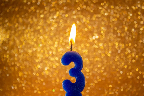 キラキラとお祝いの金の背景に数字3と誕生日キャンドル — ストック写真