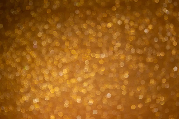 Gold background with defocused sparkles. Christmas golden background.