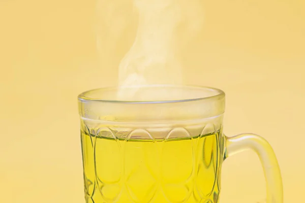 Detail Glass Mug Hot Tea Emitting Steam Yellow Background — Stock Photo, Image