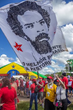 Üzerinde Lula 'nın yüzü olan dev beyaz bir bayrak sallayan biri. Fotoğraf Brezilya 'nın yeni başkanının açılış töreninde çekildi..