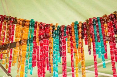 Honey-shaped sweets of various flavors and colors, inside bags, displayed for sale at a fair.