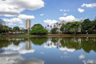Goinia kentindeki Bosque dos Buritis göllerinden birinin manzarası. Ağaçlı göl ve bulutlu mavi gökyüzü..