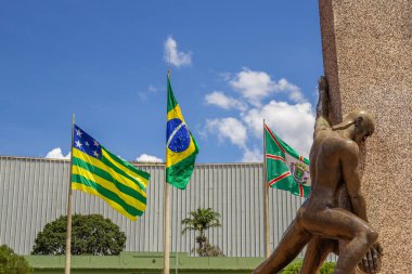Üç Yarış Anıtı. Arka planda üç bayrak asılı. Goiania şehir meydanında..