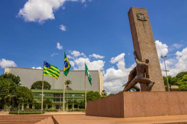 Üç Yarış Anıtı. Arka planda üç bayrak asılı. Goiania şehir meydanında..