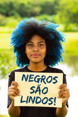 Genç bir kadın, boyalı mavi saçlı, elinde 