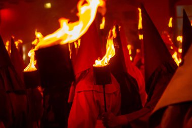 Her yıl Paskalya arifesinde Goias şehrinde gerçekleşen dini bir festival olan Fogareu Geçit Töreni sırasında ellerinde meşaleler bulunan birkaç farrikoko..