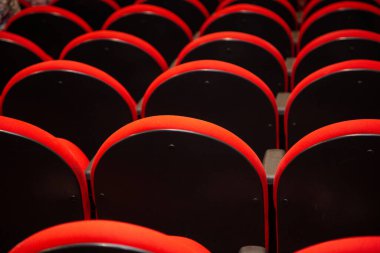 Boş bir tiyatrodaki birkaç sıra kırmızı koltuğun ayrıntıları..