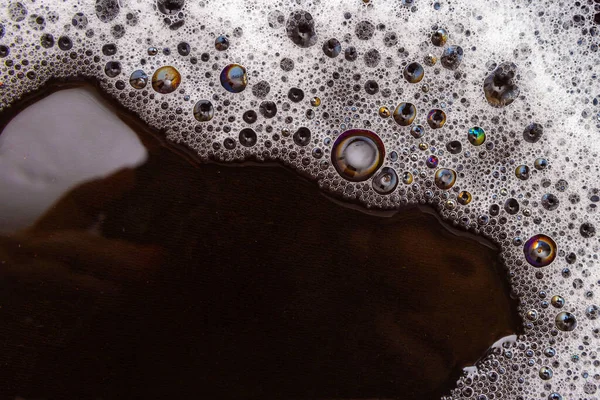 用肥皂泡沫湿透的黑色表面的宏观细节 — 图库照片
