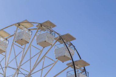  Arka planda mavi gökyüzü olan beyaz dönme dolabın ayrıntıları..