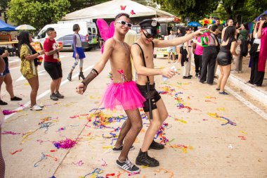 Goiania şehrindeki LGBTQIA Onur Yürüyüşü sırasında kostüm giyen ve dans eden iki genç lgbant..