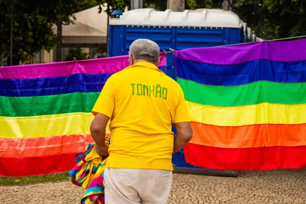一个穿黄色T恤的男人从后面卖彩虹旗照片来自Goiania市Lgbtqia Pride Parade — 图库照片