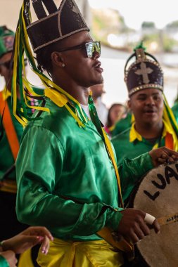 Angola ve Kongo 'dan gelen kabile geleneklerinin unsurlarının yer aldığı bir dini festival olan Kongadas sırasında davul çalan ve yeşil giyen şenliklerden oluşan bir grup..