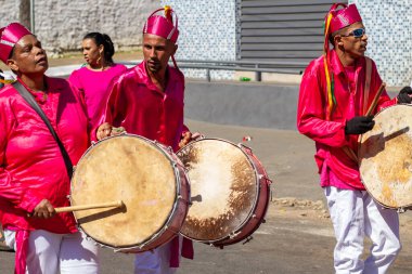 Kırmızı elbiseli, dans eden ve Congadas boyunca perküsyon enstrümanları çalan hayranlar, Angola ve Kongo 'dan gelen kabile geleneklerinin öğeleriyle dolu bir dini festival..