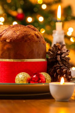 Dekorasyonlu panettone, Noel ağacı ve arka planda yanıp sönen ışıklar..